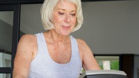 Seniorin beim Herzkreislauf-Training im Fitnessstudio