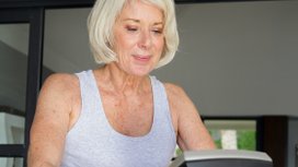 Seniorin beim Herzkreislauf-Training im Fitnessstudio