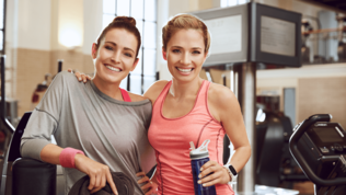 zwei junge gut aussehende Frauen im Fitnessstudio