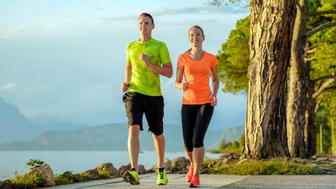 Mann und Frau laufen am See