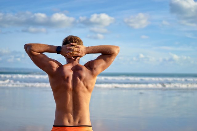 Muskelrelief des Rückens bei einem Mann am Meer